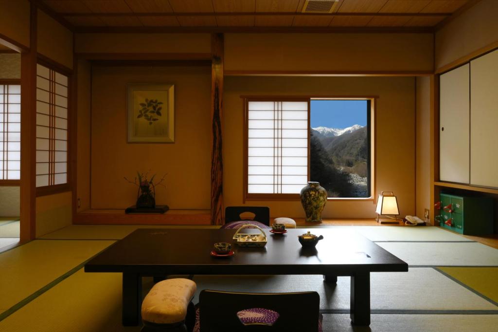 - un salon avec une table et une vue sur la montagne dans l'établissement Futari Shizuka, à Komagane