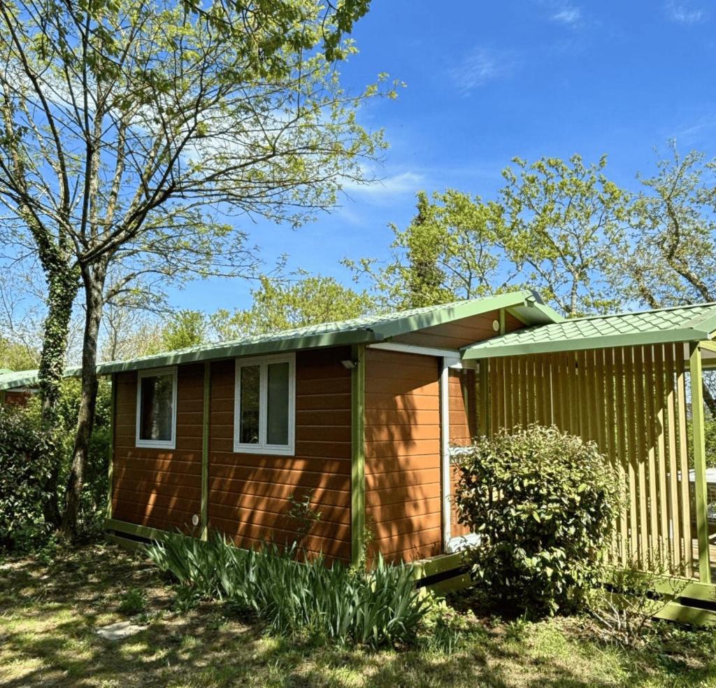 une petite maison brune avec un toit vert dans l'établissement Le Boem, à Balazuc 9 autres photos