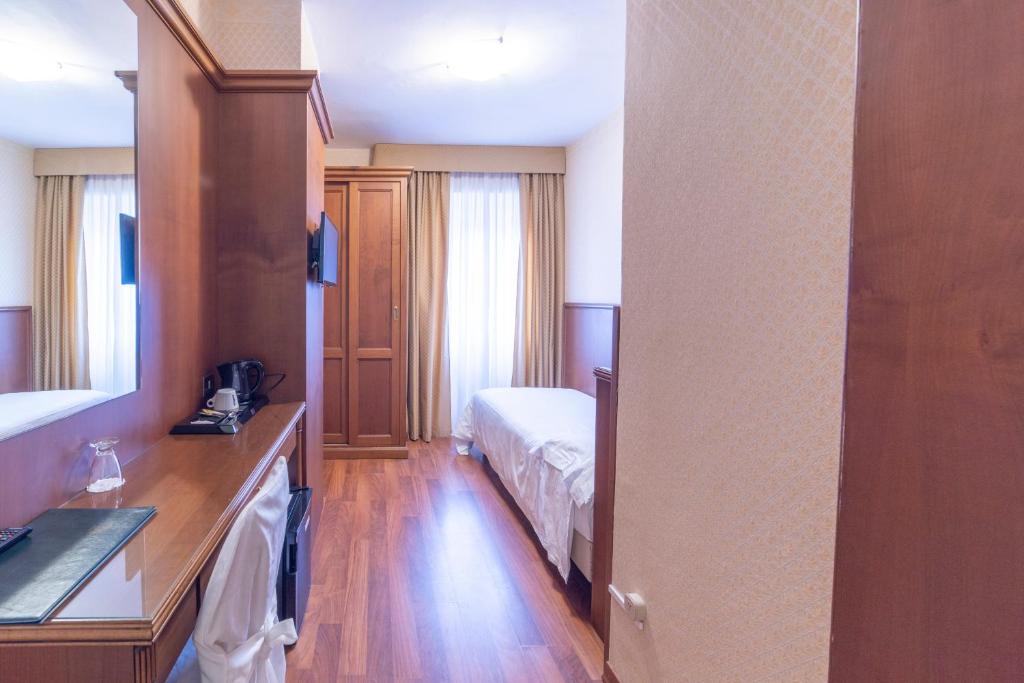 une chambre d'hôtel avec un lit et un miroir dans l'établissement Hotel Due Palme, à Mergozzo