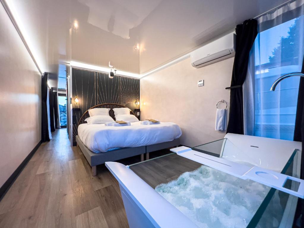 une chambre d'hôtel avec un lit et une baignoire dans l'établissement L'Escale Royale Saverne - Rhin - Strasbourg, à Saverne