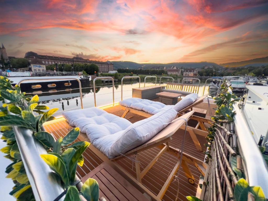 un pont de bateau avec des chaises longues et un coucher de soleil dans l'établissement L'Escale Royale Saverne - Rhin - Strasbourg, à Saverne