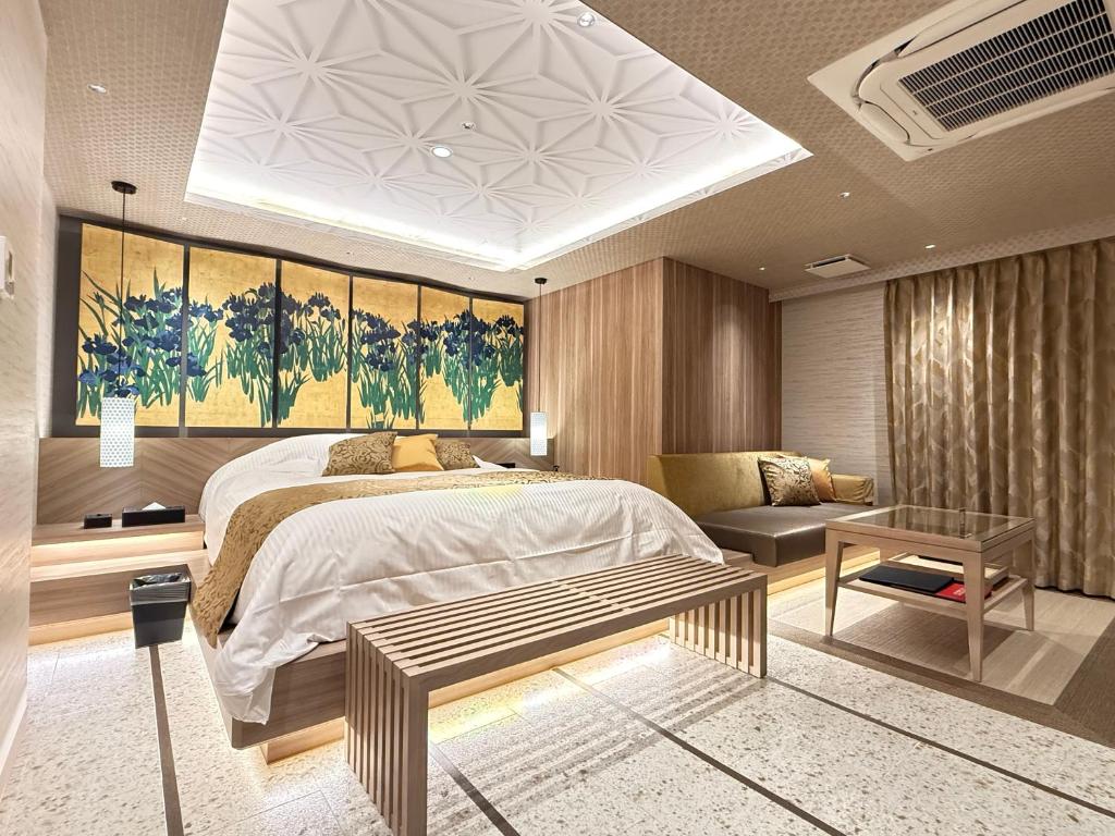 une chambre avec un grand lit et un canapé dans l'établissement ホテル 兆 各務原店 Hotel CHO Kakamigahara, à Kakamigahara