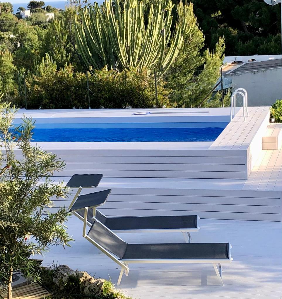 - une piscine avec 2 chaises à côté dans l'établissement La Casa del Vento Plemmirio, à Plemmirio