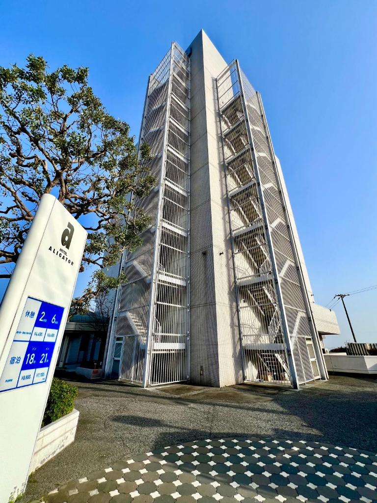 un bâtiment avec une enseigne devant lui dans l'établissement Hotel Aligator -Adult Only-, à Hatsukaichi