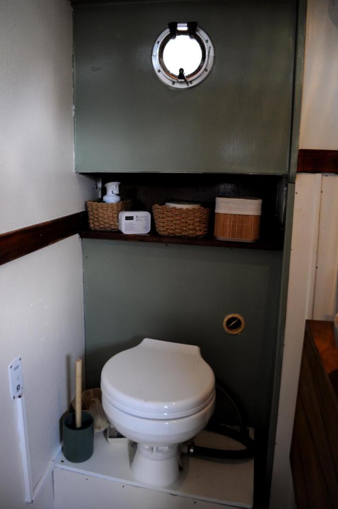 une salle de bain avec des toilettes blanches dans une chambre dans l'établissement C'la Vie - Proche Fontainebleau - Bateau, à Nemours