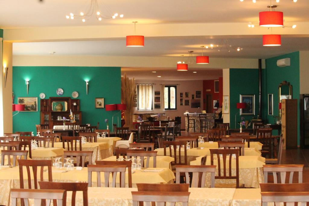 une salle à manger remplie de tables et de chaises dans l'établissement Hotel Resort Poggio degli Ulivi, à Rodi Garganico