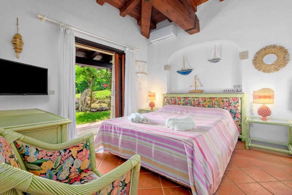 - une chambre avec un lit, deux chaises et une télévision dans l'établissement Villa Miramar, à Puntaldia