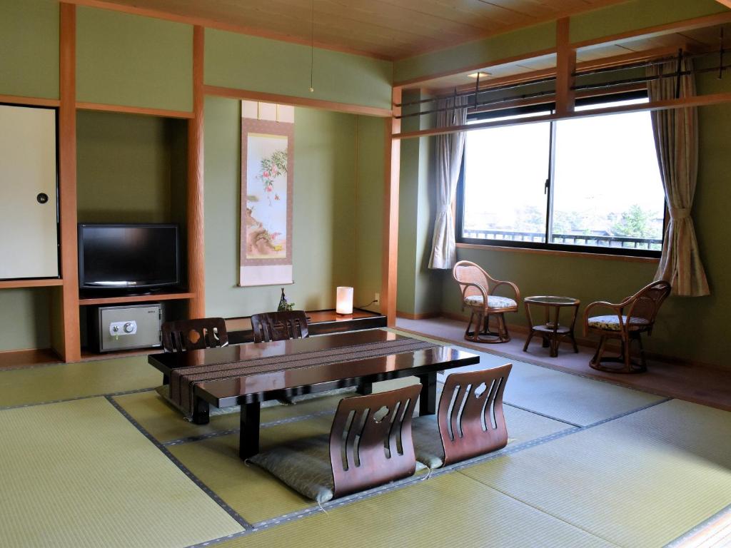 un salon avec une table et des chaises dans l'établissement 坂本屋旅館, à Kyōtango