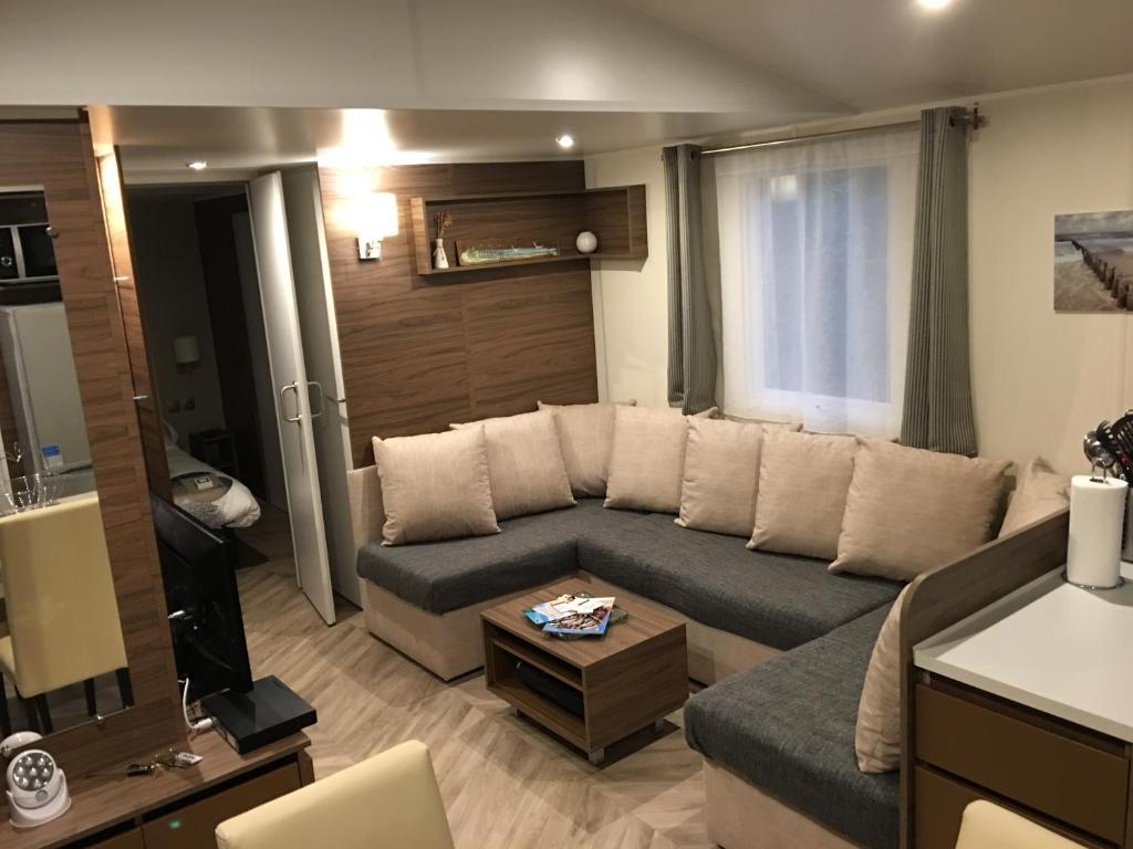 un salon avec un canapé et une table dans l'établissement Mobilhome familial 6 à 7 p 3 chambres 42 m2 Saint Brévin Les Pierres Couchées, à Saint-Brévin-les-Pins