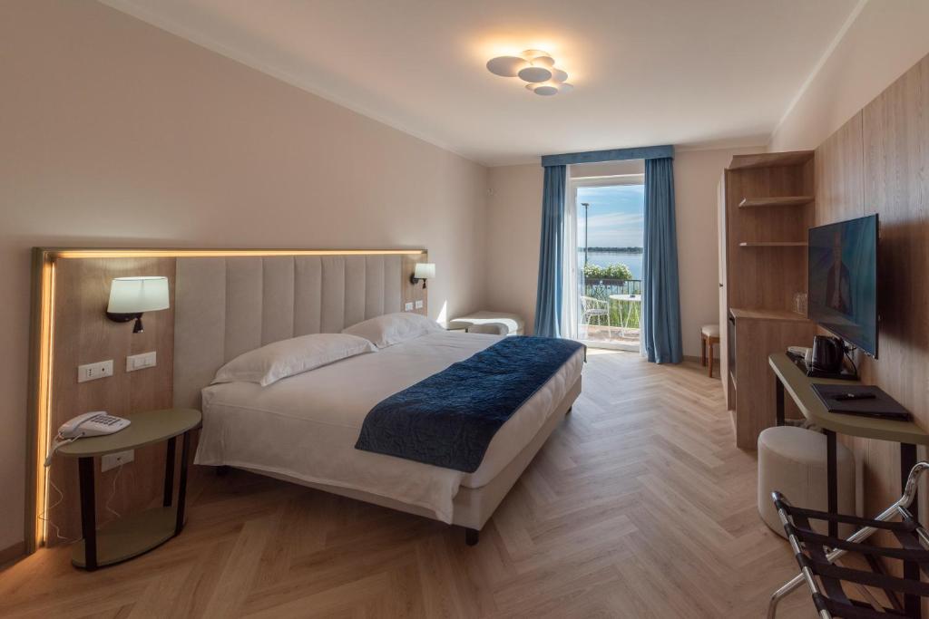 une chambre d'hôtel avec un lit et une télévision dans l'établissement Hotel Due Palme, à Mergozzo