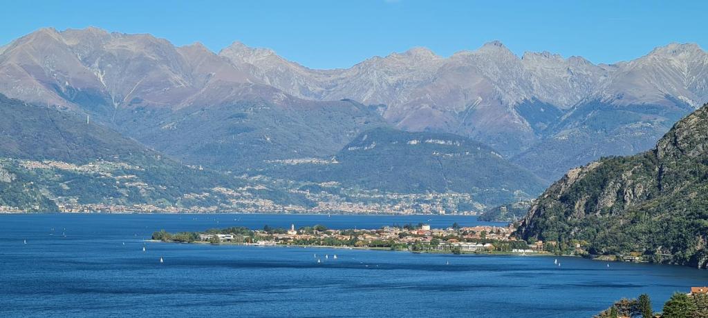 une grande étendue d'eau avec des montagnes en arrière-plan dans l'établissement Villa Sunrise - Luxury property with pool & large private garden, few steps from the beach, ideal for families and people with mobility issues, à Dervio