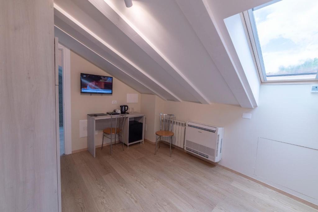 une chambre mansardée avec un bureau et une fenêtre dans l'établissement Hotel Due Palme, à Mergozzo