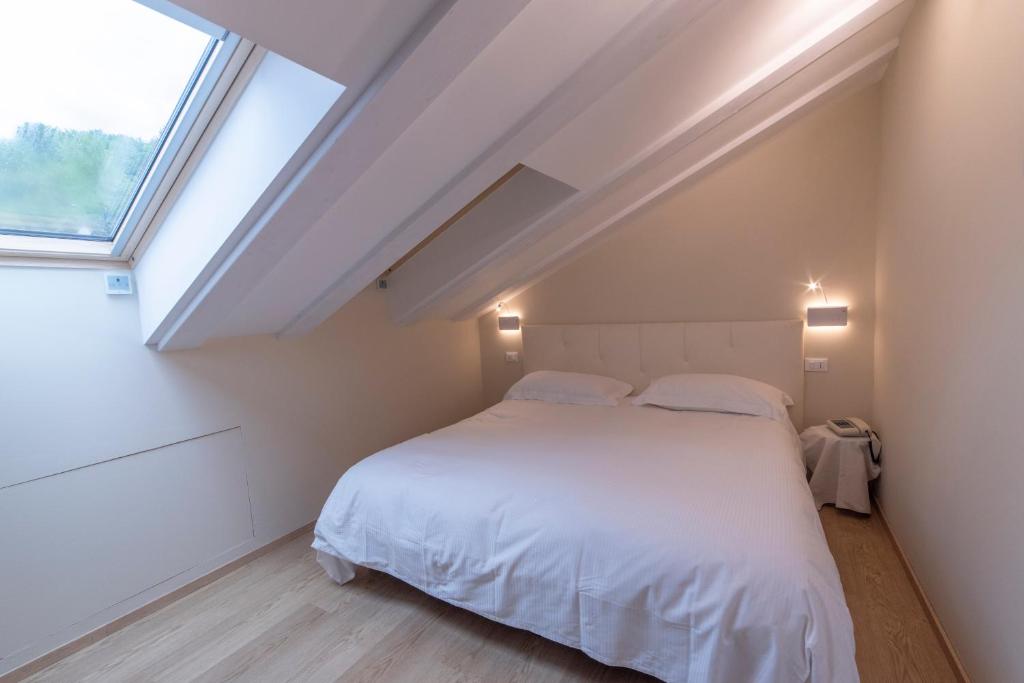 une chambre avec un lit blanc et une fenêtre dans l'établissement Hotel Due Palme, à Mergozzo 261 autres photos