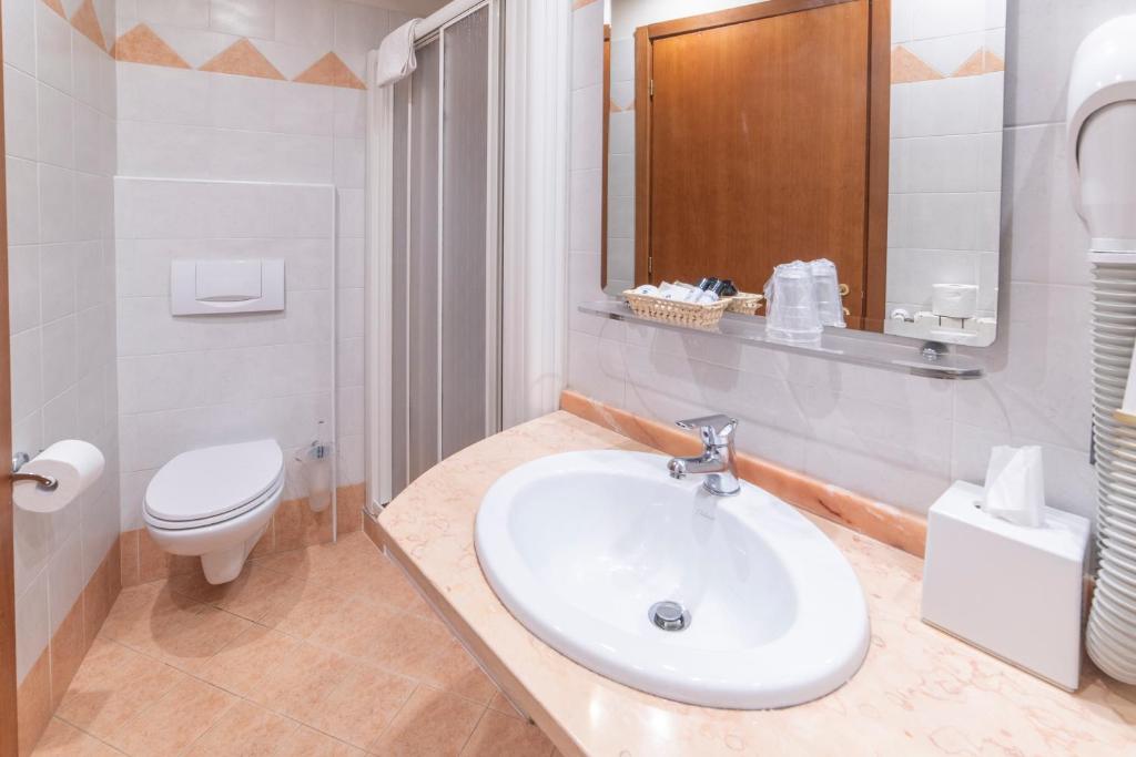 une salle de bain blanche avec un lavabo et des toilettes dans l'établissement Hotel Bettina, à Mergozzo 26 autres photos