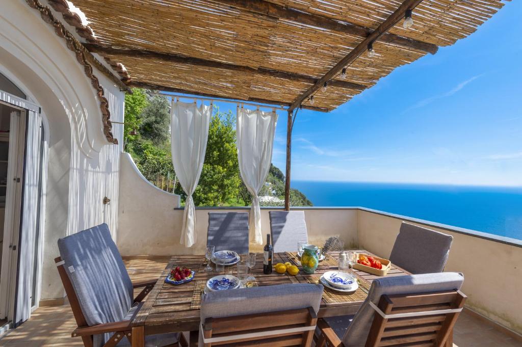 une table et des chaises sur une terrasse avec vue sur l'océan dans l'établissement Casa Punta Di Diamante - 300 stairs to the Paradise!, à Praiano