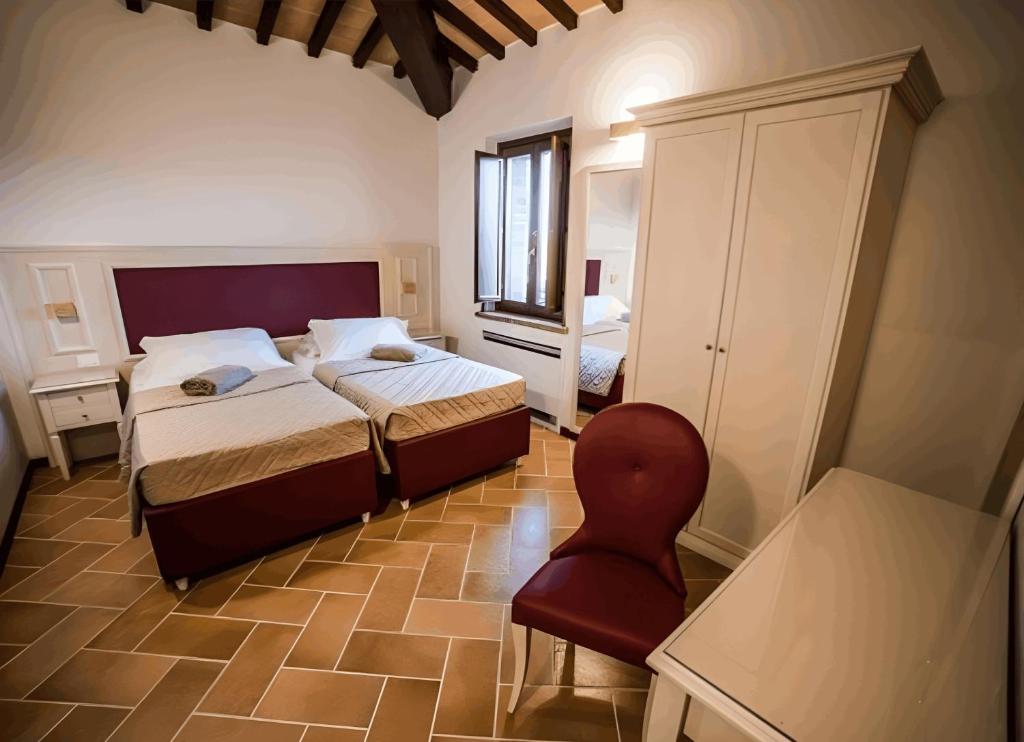 une chambre avec un lit et une chaise rouge dans l'établissement Macchie San Vincenzo - Villa Privata con Piscina e Giardino ad uso esclusivo o camere, à Chiusi 38 autres photos
