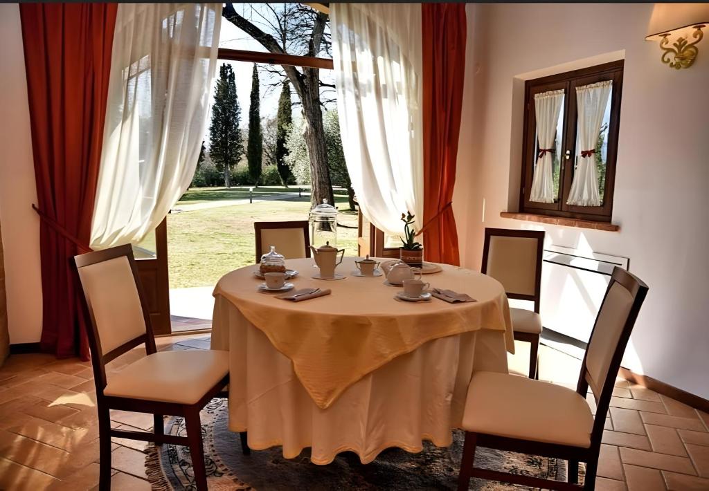 une salle à manger avec une table et des chaises et une fenêtre dans l'établissement Macchie San Vincenzo - Villa Privata con Piscina e Giardino ad uso esclusivo o camere, à Chiusi