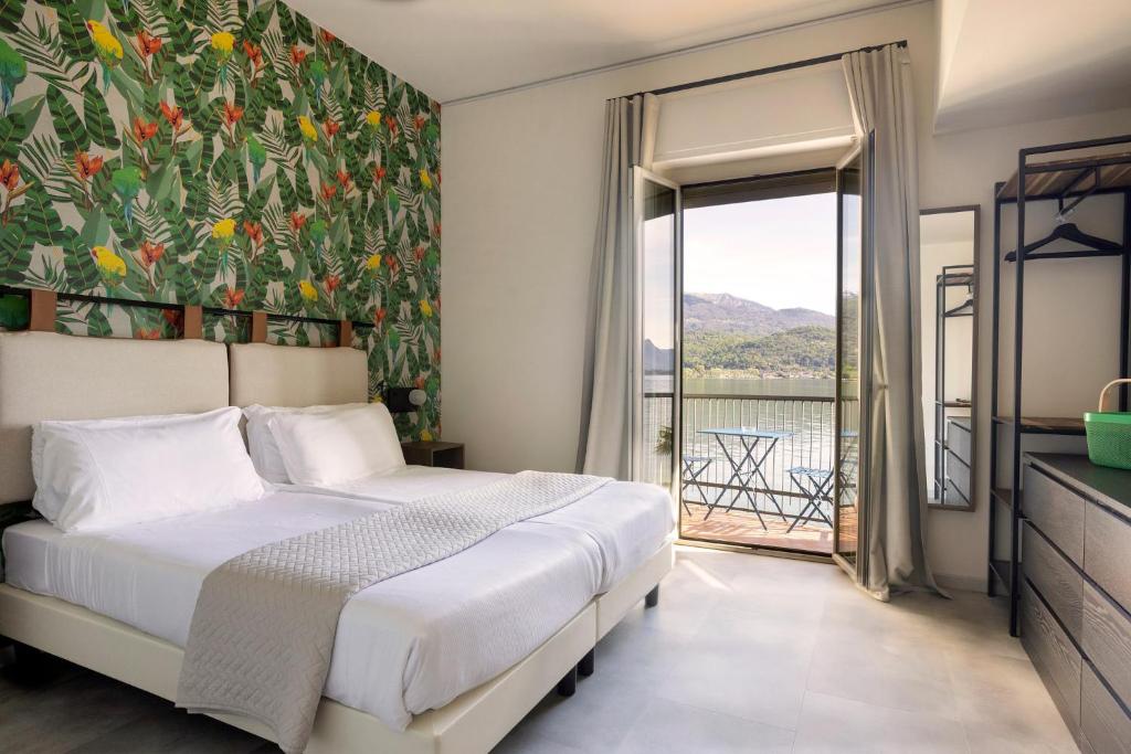 une chambre avec un lit et une grande fenêtre dans l'établissement Hotel Carillon, à Baveno