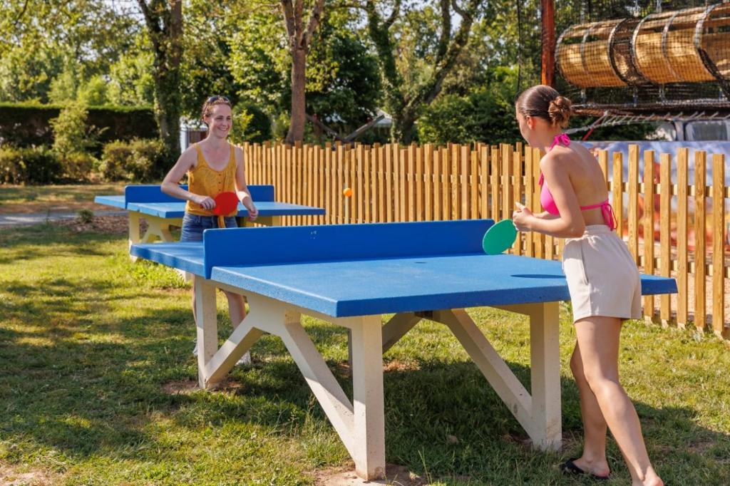 deux femmes jouant au ping-pong dans l'établissement Camping maeva Escapades Le Bois Joli, à Bois-de-Cené