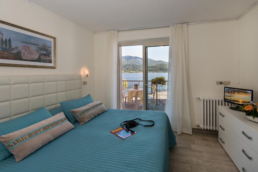 - une chambre avec un lit bleu et un livre dans l'établissement Hotel Carillon, à Baveno