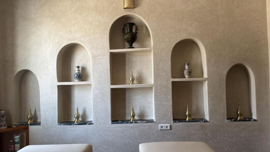un mur avec des étagères avec des vases dessus dans l'établissement Riad Dar Laura, à Fès