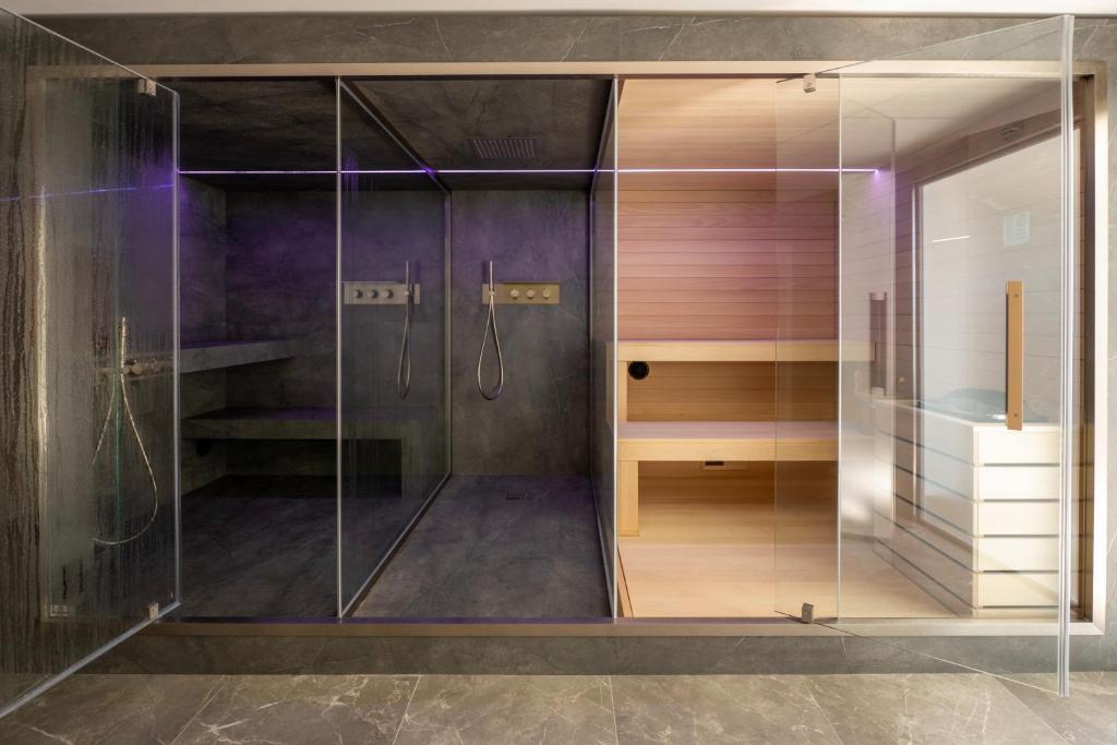 une douche avec une porte vitrée dans une salle de bain dans l'établissement Hotel Astoria, à Caorle 47 autres photos