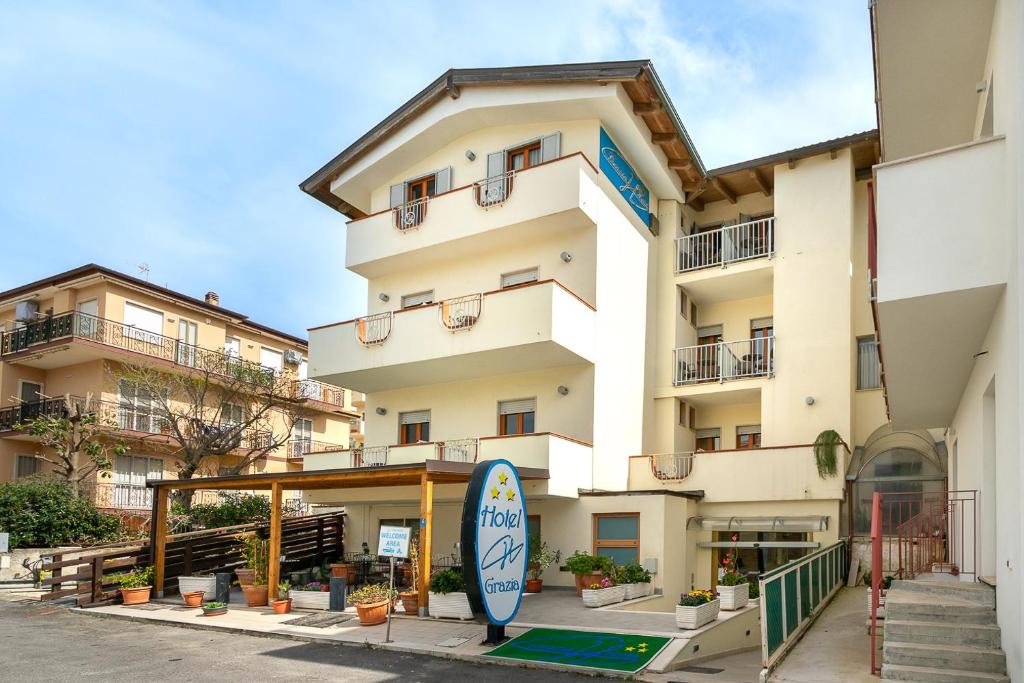un bâtiment devant lequel se trouve une planche de surf dans l'établissement Grazia Hotel, à Sperlonga