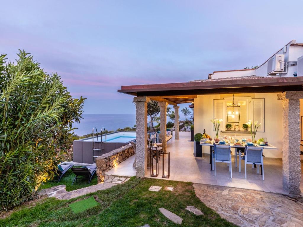 une salle à manger extérieure d'une maison avec vue sur l'océan dans l'établissement Villa in Sardinia near Porto Ottiolu Beach, à Porto Ottiolu