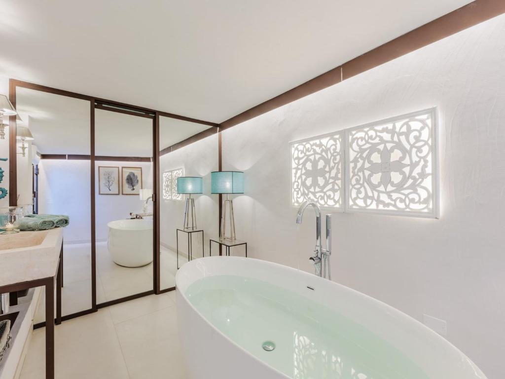 une salle de bain blanche avec une baignoire et un lavabo dans l'établissement Villa in Sardinia near Porto Ottiolu Beach, à Porto Ottiolu 88 autres photos