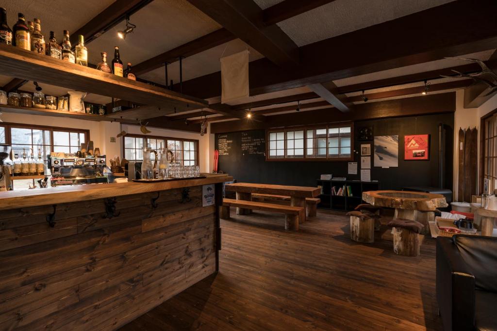 - un bar dans un restaurant doté de parquet et de tables dans l'établissement Shirakaba, à Nozawa Onsen
