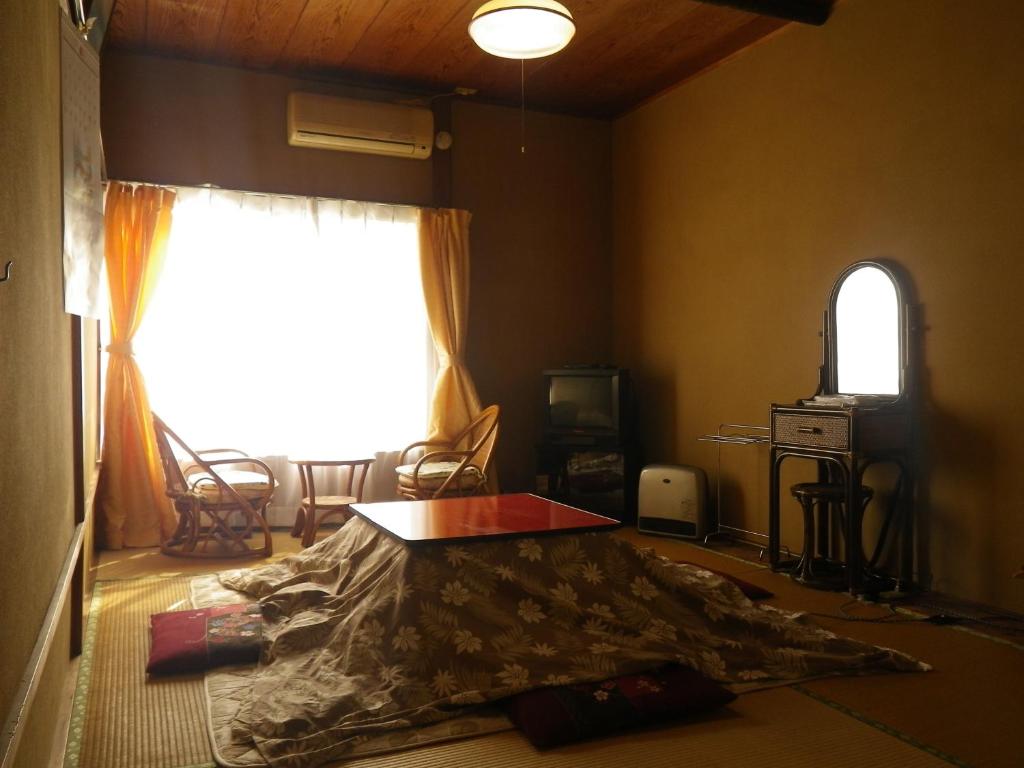 un salon avec un lit dans une chambre avec une fenêtre dans l'établissement Fukushimakan, à Hakone 37 autres photos