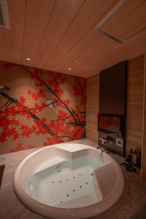 une grande baignoire dans une salle de bain avec un tableau dans l'établissement ホテル 兆 各務原店 Hotel CHO Kakamigahara, à Kakamigahara