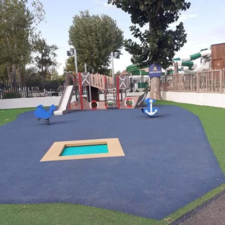 une aire de jeux avec un toboggan dans un parc dans l'établissement Mobil home Camping La Marine, au Grau-du-Roi