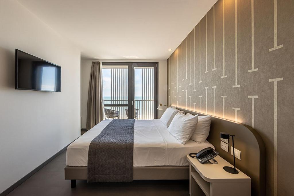 une chambre d'hôtel avec un lit et une télévision dans l'établissement DIVA HOTEL LIGNANO - Adults Only, à Lignano Sabbiadoro