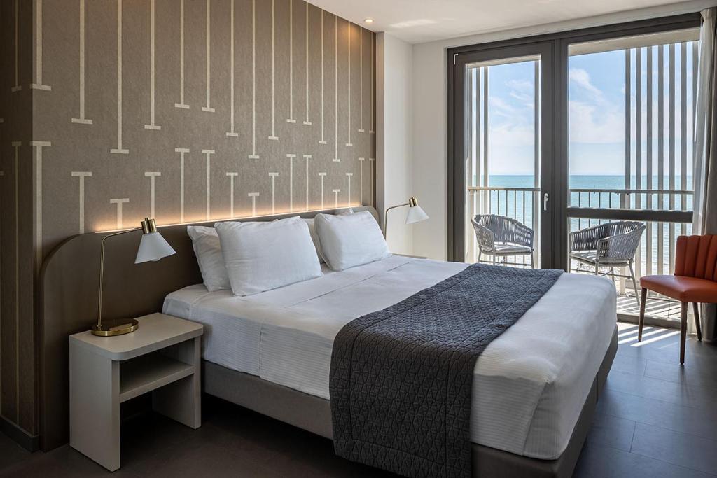 une chambre avec un grand lit et un balcon dans l'établissement DIVA HOTEL LIGNANO - Adults Only, à Lignano Sabbiadoro 63 autres photos