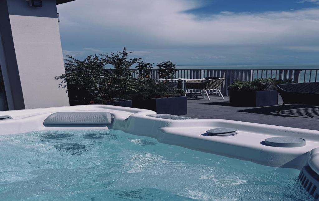 - un bain à remous sur une terrasse avec vue sur l'océan dans l'établissement DIVA HOTEL LIGNANO - Adults Only, à Lignano Sabbiadoro