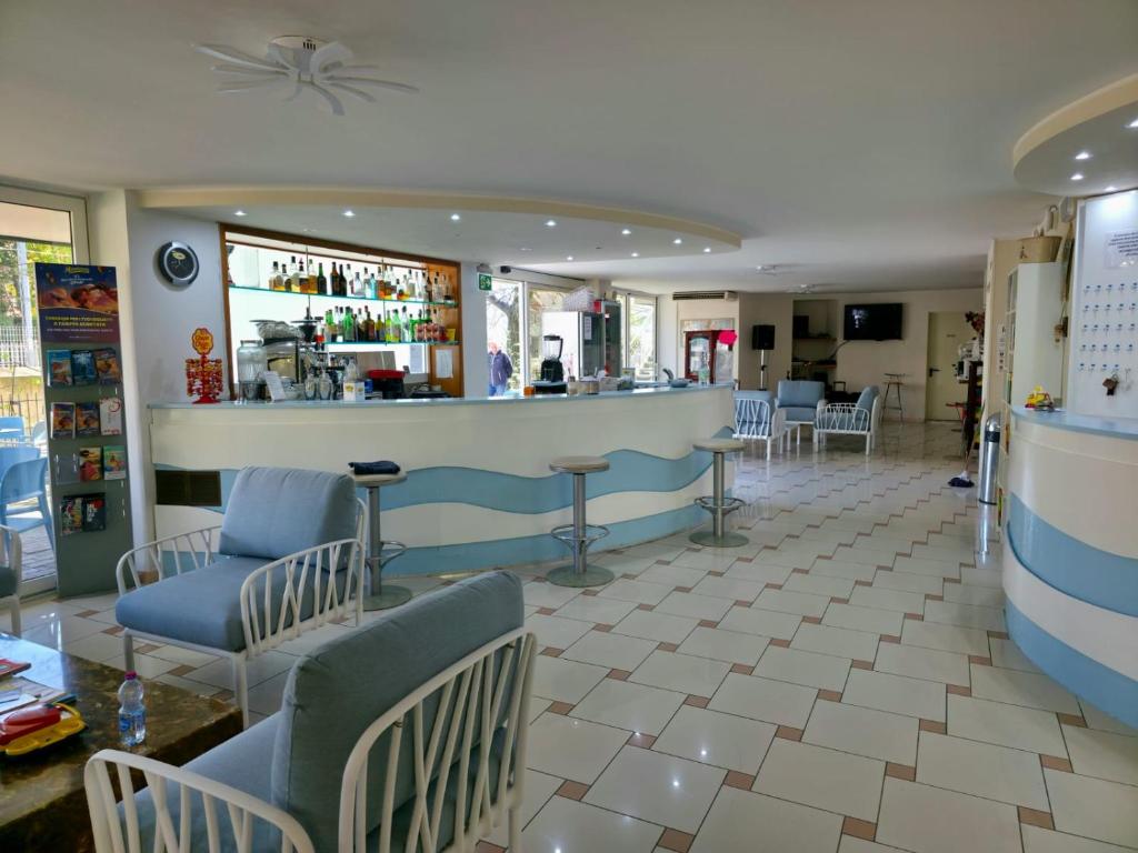un bar dans un restaurant avec des chaises et un comptoir dans l'établissement Hotel Sympathy, à Rimini