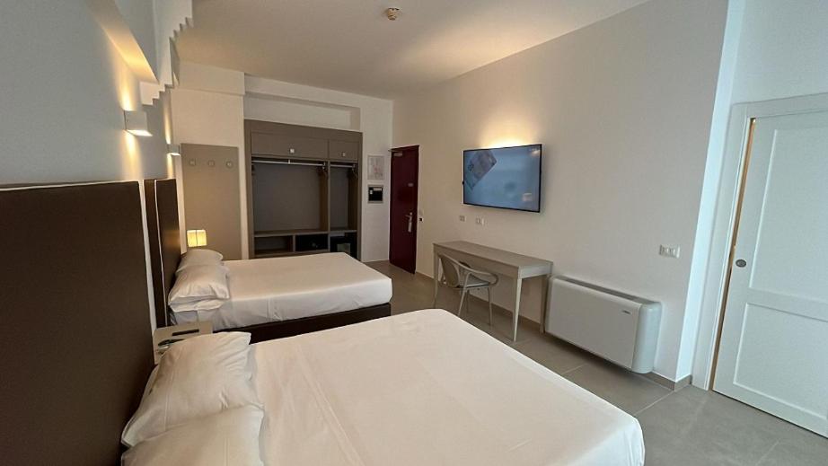 une chambre d'hôtel avec deux lits et une télévision dans l'établissement Hotel Gajeta, à Gaète