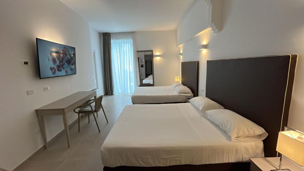 une chambre d'hôtel avec deux lits et un bureau dans l'établissement Hotel Gajeta, à Gaète