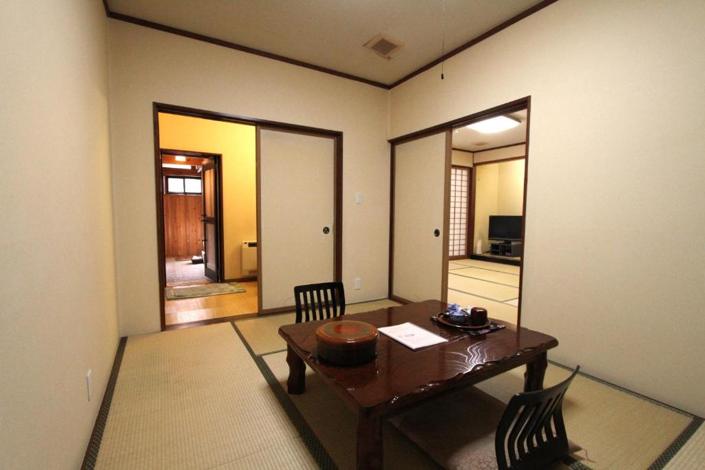 - une salle à manger avec une table et deux chaises dans l'établissement ひらゆの森別邸湯う香三蔵庵, à Takayama