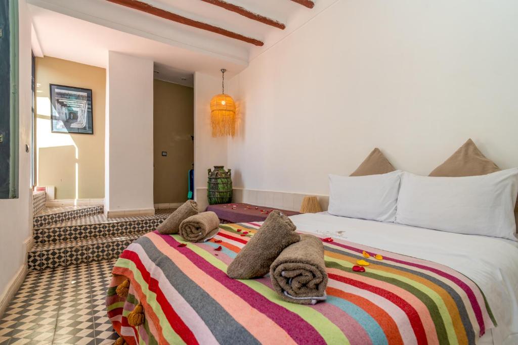 une chambre avec un grand lit avec des serviettes dessus dans l'établissement Riad Nafora, à Marrakech