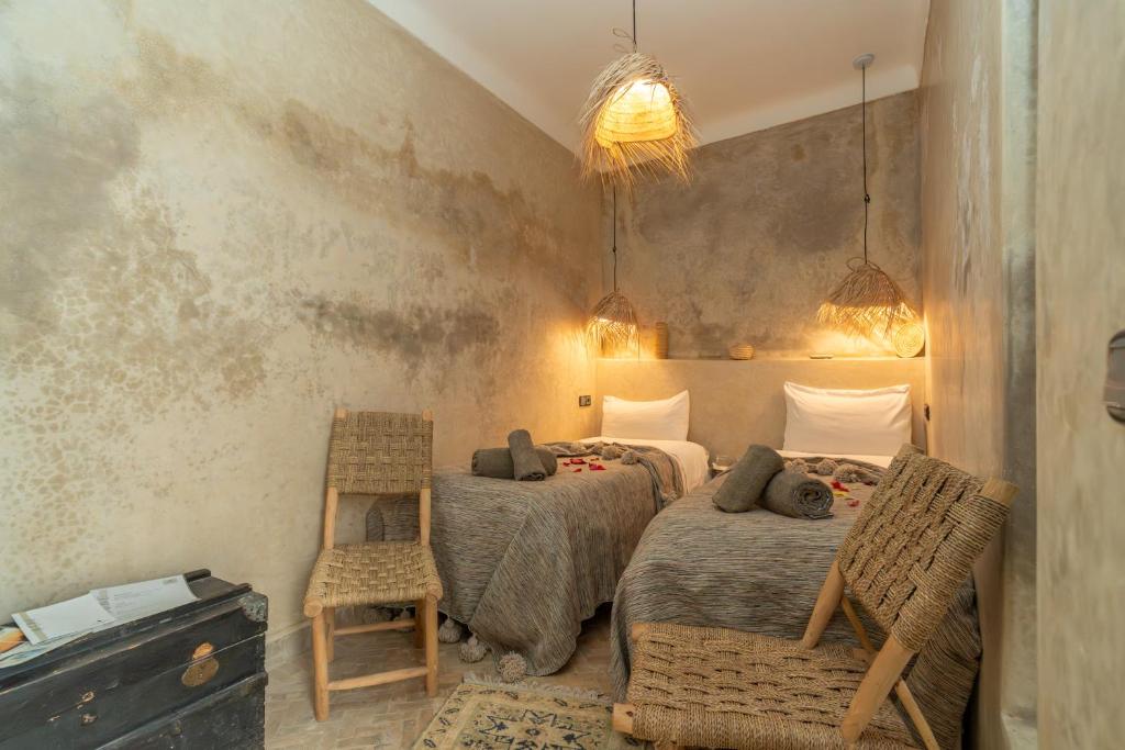 une chambre avec deux lits et deux chaises dans l'établissement Riad Nafora, à Marrakech 37 autres photos