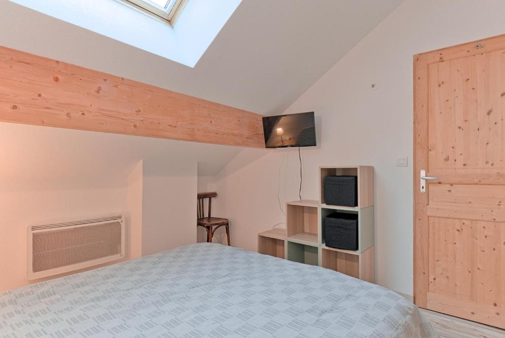 - une chambre avec un lit et une télévision au plafond dans l'établissement Résidence récente au coeur des monts du Cantal, à Laveissière