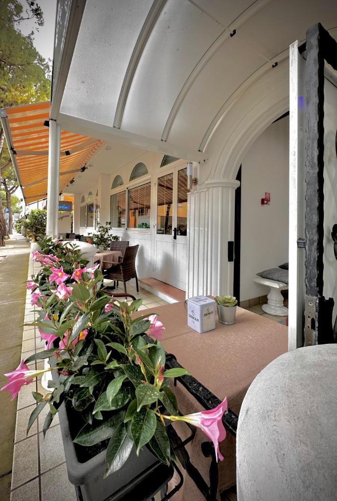 une pièce avec des tables et des fleurs dans un bâtiment dans l'établissement Hotel La Parigina, à Lignano Sabbiadoro