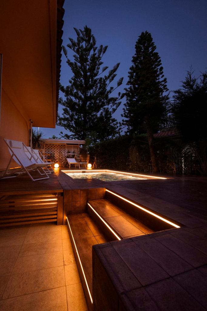 un patio avec des lumières sur le côté d'un bâtiment dans l'établissement Hotel Ristorante Le Rose, à Briatico