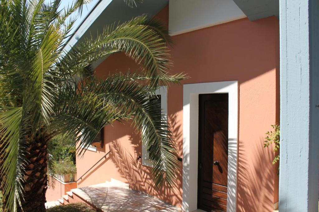 une maison avec un palmier devant une porte dans l'établissement Villino con piscina, à Terni