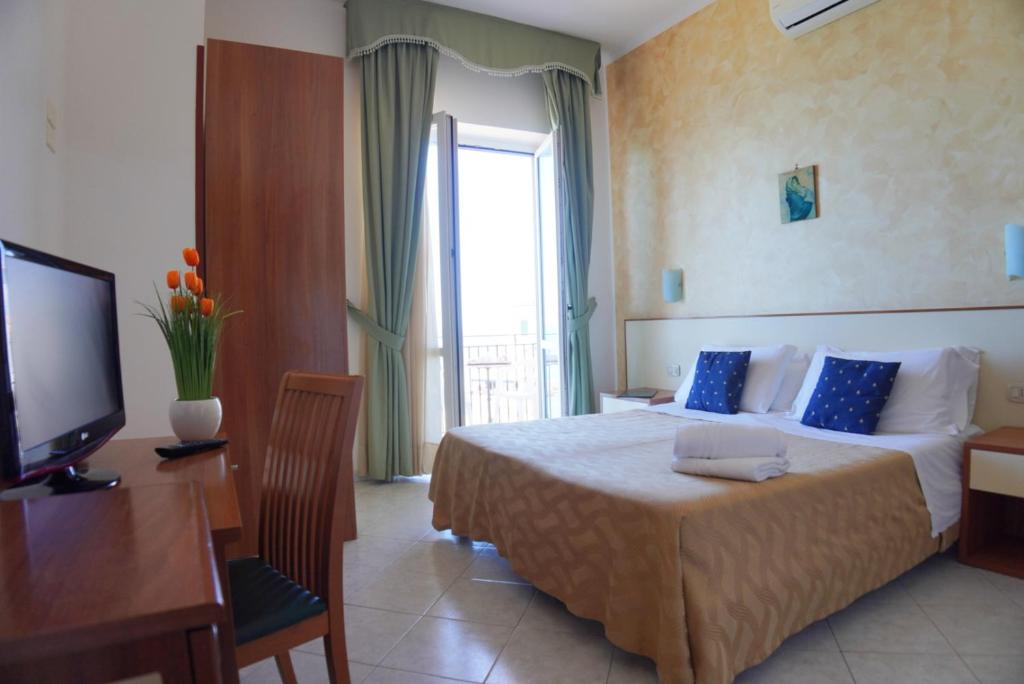 une chambre d'hôtel avec un lit et une télévision dans l'établissement New Hotel Sonia, à Santa Maria di Castellabate