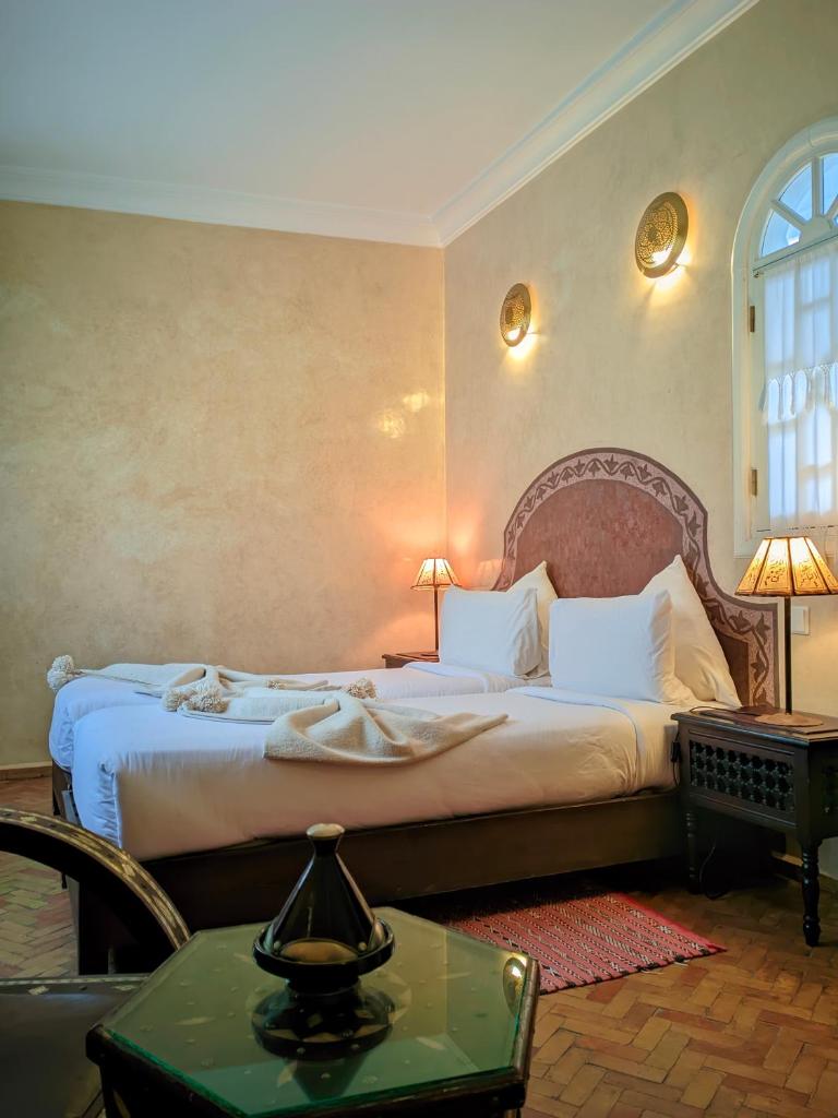 - une chambre d'hôtel avec un lit et une table avec un sidx dans l'établissement La Fontaine Bleue, à Essaouira