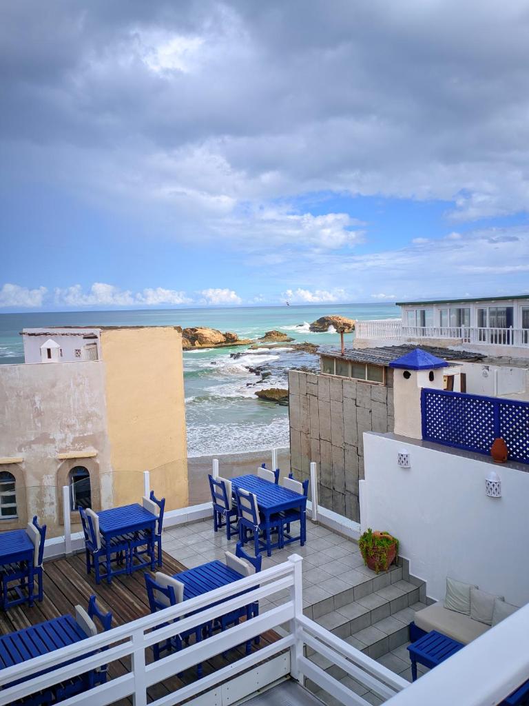 d'un balcon avec des chaises bleues et une vue sur l'océan. dans l'établissement La Fontaine Bleue, à Essaouira