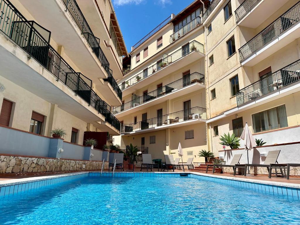 une piscine devant un bâtiment dans l'établissement Hotel Soleado, à Taormine